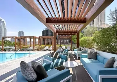 a patio with blue couches and a pool at Full Burj Khalifa & Fountain View Living & Bed in Dubai