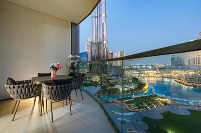 a balcony with a table and chairs and a view of a city at Iconic Views - Exclusive Burj Khalifa & Fountain Views from Every Angle in Dubai