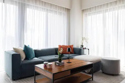 a living room with a blue couch and a coffee table at Arthouse Royale - 2BR with Burj Khalifa Views, Swimming Pool & Gym in Dubai