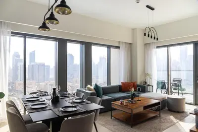 a living room with a dining table and a large window at Arthouse Royale - 2BR with Burj Khalifa Views, Swimming Pool & Gym in Dubai