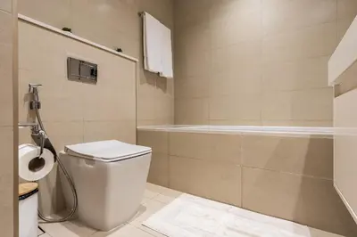 a bathroom with a toilet and a bath tub at Arthouse Royale - 2BR with Burj Khalifa Views, Swimming Pool & Gym in Dubai
