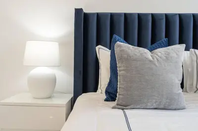 a bed with a pillow and a lamp on a night stand at DownTown, Amazing Business Bay Skyline Views in Dubai