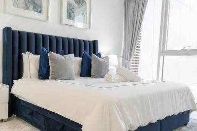 a large bed with blue and white pillows at DownTown, Amazing Business Bay Skyline Views in Dubai