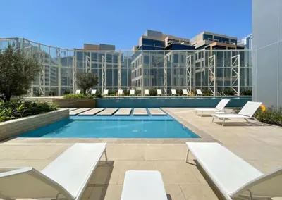 a swimming pool with lounge chairs and a building at DownTown, Amazing Business Bay Skyline Views in Dubai