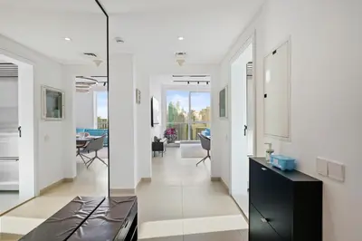 a living room with white walls and a glass wall at Ferrari Inspired Modern 3BHK with maids room and Full Sea View in Dubai