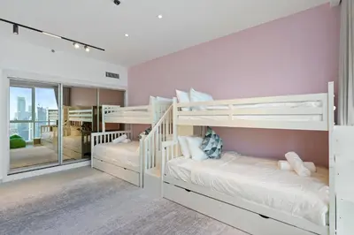 two bunk beds in a bedroom with pink walls at Ferrari Inspired Modern 3BHK with maids room and Full Sea View in Dubai