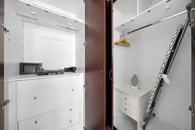 a closet with white cabinets and a staircase at Newly-furnished 1BR at DEC Tower 2 in Dubai