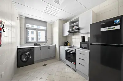 a kitchen with a washing machine and a washer at Newly-furnished 1BR at DEC Tower 2 in Dubai