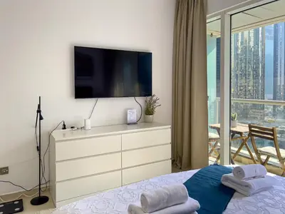 a bedroom with a dresser with a television on it at Lovely Studio at The Arch Tower JLT in Dubai