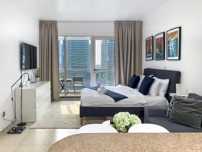 a living room with a bed and a couch at Lovely Studio at The Arch Tower JLT in Dubai