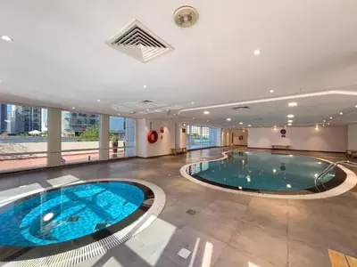 a large swimming pool in a large room with a building at Lovely Studio at The Arch Tower JLT in Dubai
