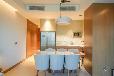 a kitchen with a table and some white chairs at 3 BHK Luxury Living at The Address Opera in Dubai