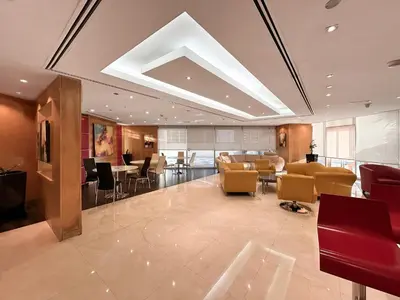 a lobby with chairs and tables in a building at Trophy- Radiant Retreat in JLT With Skyline View in Dubai