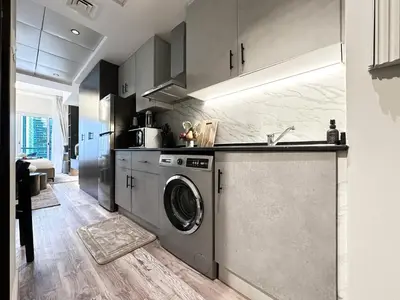 a kitchen with a washing machine and a sink at Trophy- Radiant Retreat in JLT With Skyline View in Dubai