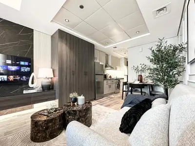 a living room with a couch and a kitchen at Trophy- Radiant Retreat in JLT With Skyline View in Dubai