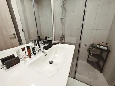 a bathroom with a white sink and a shower at Chic Modern Studio in Luma21, Best Pool & Gym in JVC Dubai in Dubai