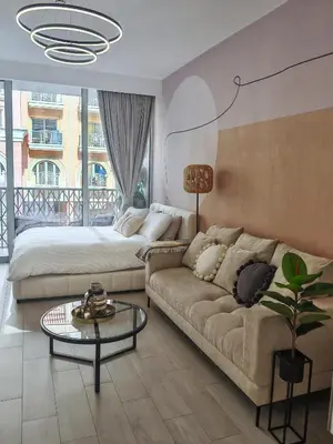 a living room with a couch and a bed at Chic Modern Studio in Luma21, Best Pool & Gym in JVC Dubai in Dubai