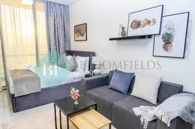 a living room with a couch and a bed at Bloomfields Luxury Escape Studio In Samana Golf in Dubai