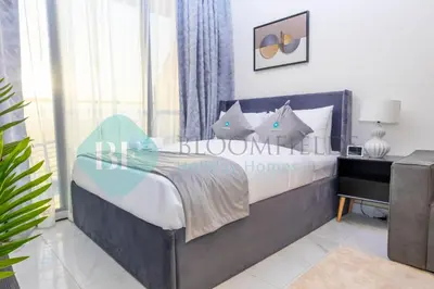 a bedroom with a bed and a desk and a window at Bloomfields Luxury Escape Studio In Samana Golf in Dubai