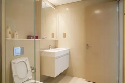 a bathroom with a toilet and a sink and a shower at Cozy 1-BR in the heart of Dubai with skyline views in Dubai