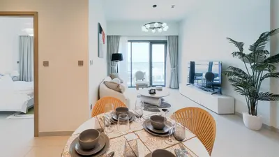 a living room with a dining room table and chairs at Cozy 1-BR in the heart of Dubai with skyline views in Dubai