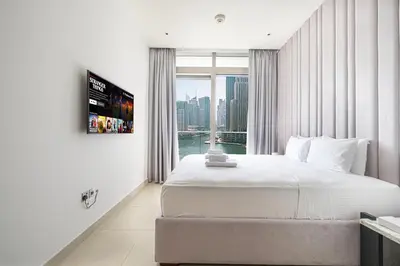 a bedroom with a large bed and a large window at 3BR Full Marina View for 8 Near The Metro! in Dubai