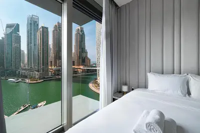 a bedroom with a view of the water and skyscrapers at 3BR Full Marina View for 8 Near The Metro! in Dubai