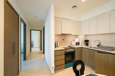 a kitchen with white cabinets and a stairway leading into a room at Stunning 2BR Apt Burj Royale 10 mins walk to Dubai mall in Dubai