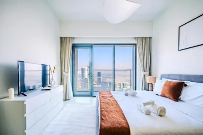 a bedroom with a large bed with a large window at Stunning 2BR Apt Burj Royale 10 mins walk to Dubai mall in Dubai