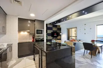 a kitchen and living room with a table and chairs at Upgraded 1B with Beach Access and Ain Dubai Views in Dubai