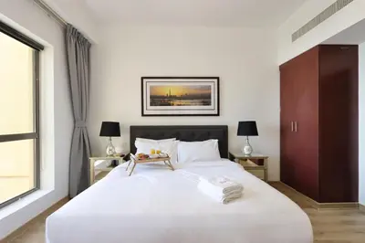 a bedroom with a large white bed and a window at Upgraded 1B with Beach Access and Ain Dubai Views in Dubai