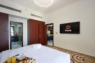 a room with a table and a tv on the wall at Upgraded 1B with Beach Access and Ain Dubai Views in Dubai