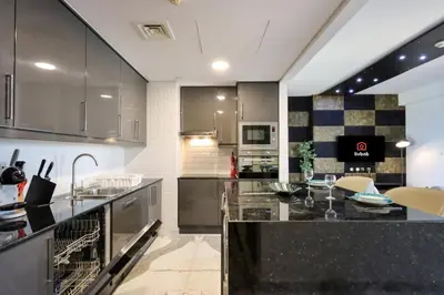 a kitchen with stainless steel appliances and black counter tops at Upgraded 1B with Beach Access and Ain Dubai Views in Dubai