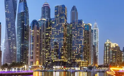 a large city with tall skyscrapers at night at Cosy Apartment Marina Gate in Dubai