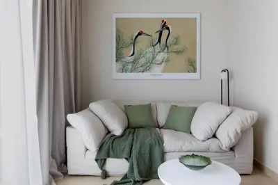 a living room with a couch and two birds at Cosy Apartment Marina Gate in Dubai