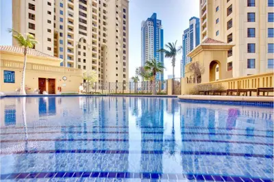 a swimming pool in a city with tall buildings at Breathtaking Sea and Palm View Spacious Studio with Vibrant Vibes in JBR By SWEET HOMES in Dubai