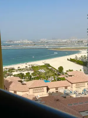 a view of a beach and the ocean from a building at Breathtaking Sea and Palm View Spacious Studio with Vibrant Vibes in JBR By SWEET HOMES in Dubai