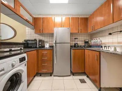a kitchen with a refrigerator and a washing machine at Spacious Home in the heart of Marina w Seaview in Dubai
