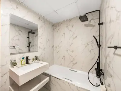 a white bathroom with a sink and a mirror at Spacious Home in the heart of Marina w Seaview in Dubai