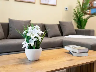 a white vase with white flowers on a coffee table at Spacious Home in the heart of Marina w Seaview in Dubai