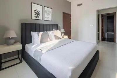 a bedroom with a large bed with white sheets and pillows at Frank Porter - Dezire Residences in Dubai