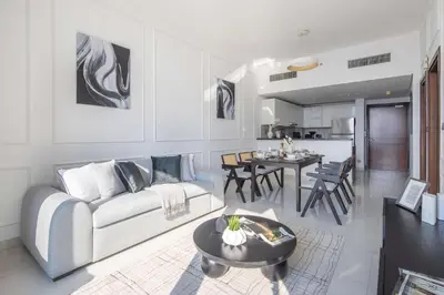 a white living room with a couch and a table at Frank Porter - Dezire Residences in Dubai
