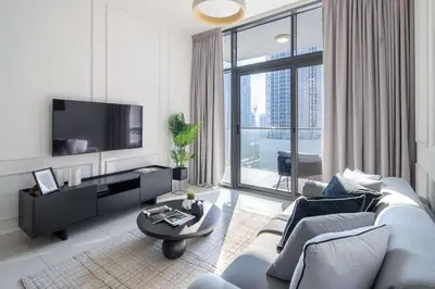 a living room with a couch and a tv at Frank Porter - Dezire Residences in Dubai