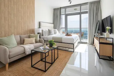 a living room with a bed and a couch at Frank Porter - Damac Carson B in Dubai
