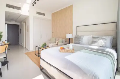 a bedroom with a large bed and a living room at Frank Porter - Damac Carson B in Dubai
