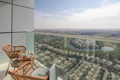 a balcony with two chairs and a view of a city at Frank Porter - Damac Carson B in Dubai