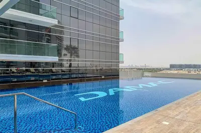 a large building with a swimming pool in front of it at Frank Porter - Damac Carson B in Dubai