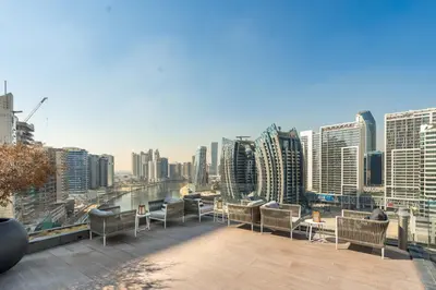 a balcony with chairs and tables and a city skyline at GuestReady - Urban retreat at 15 Northside in Dubai