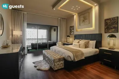 a bedroom with a large bed and a living room at Higuests - Luxurious 2BR Haven in Iconic Palm Jumeirah in Dubai