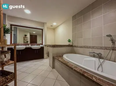 a large bathroom with two sinks and a tub at Higuests - Luxurious 2BR Haven in Iconic Palm Jumeirah in Dubai